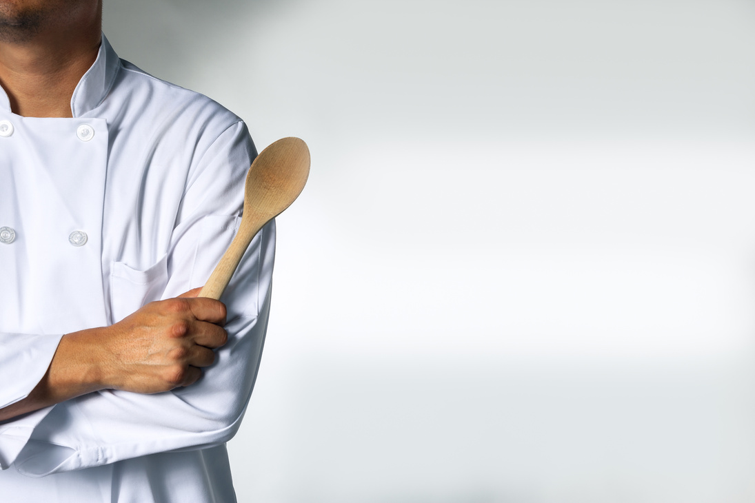 Chef with wooden spoon background with space for text
